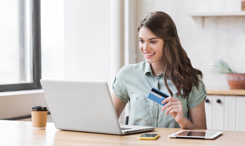 Lady with credit card on laptop.