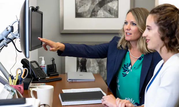 Women advisors viewing monitor.