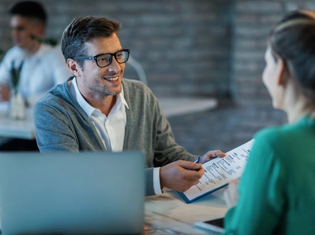 Man in glasses smiling in an office.